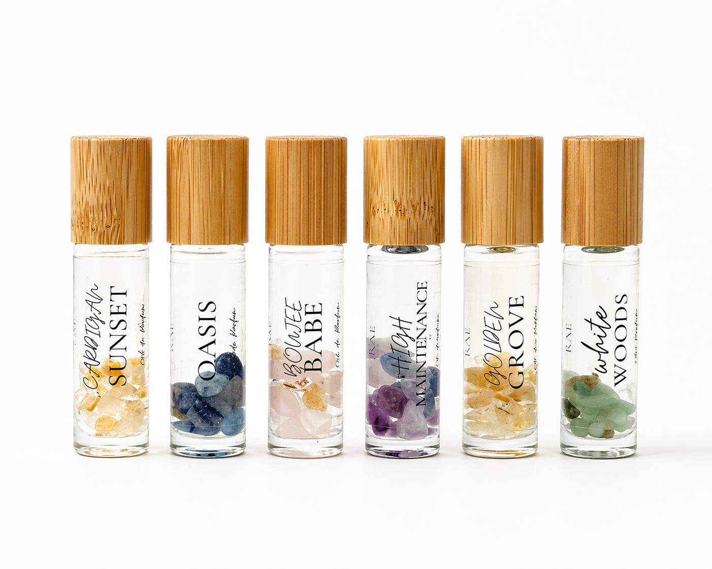 Set of six rollerball bottles with bamboo caps on a white background.