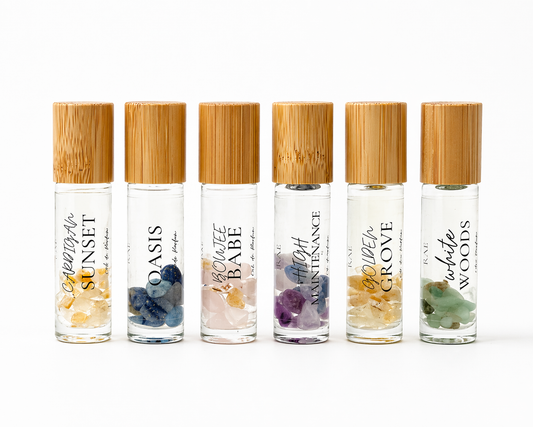 Set of six rollerball bottles with bamboo caps on a white background.