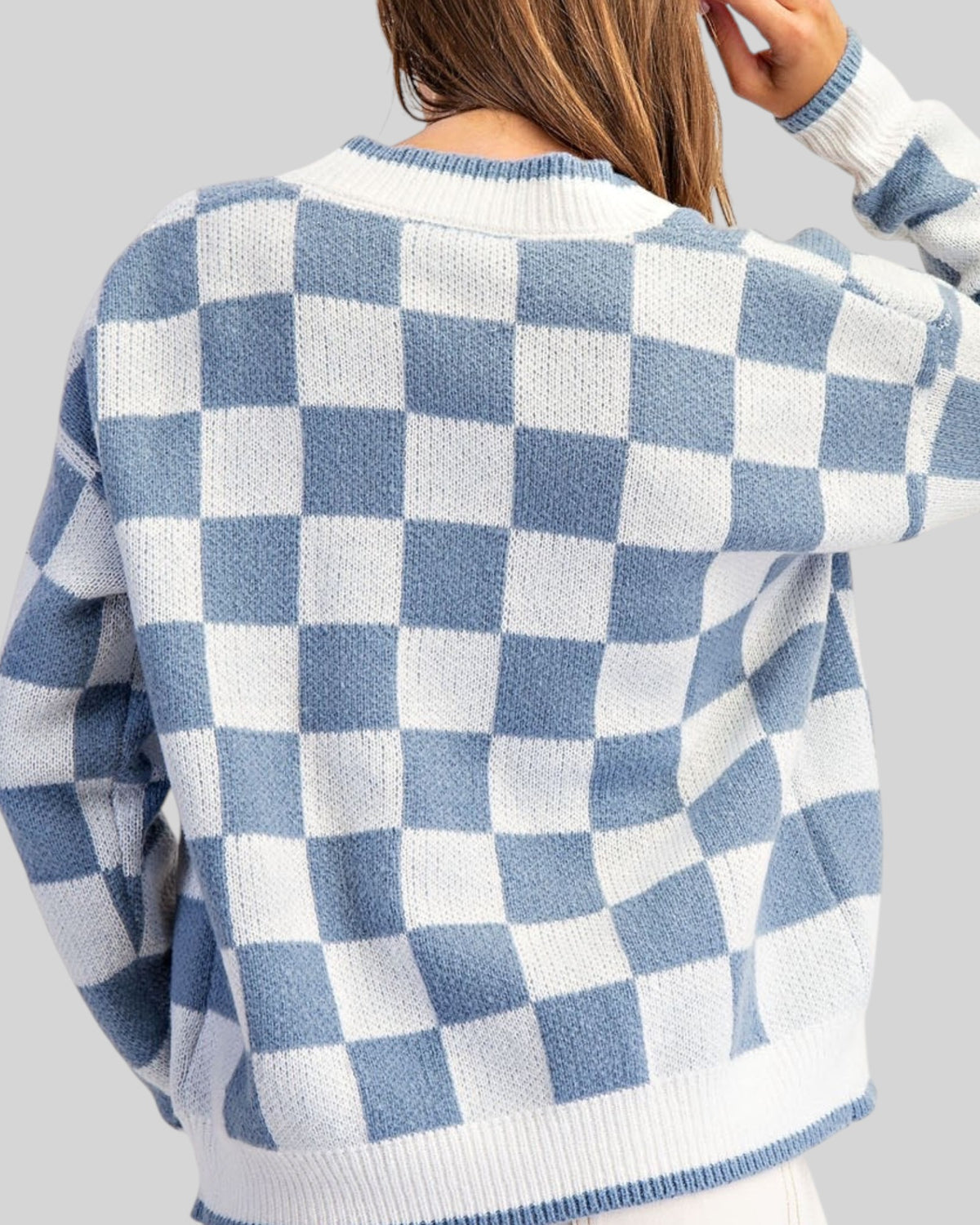 Back view of a blue and white checkerboard cardigan sweater. 