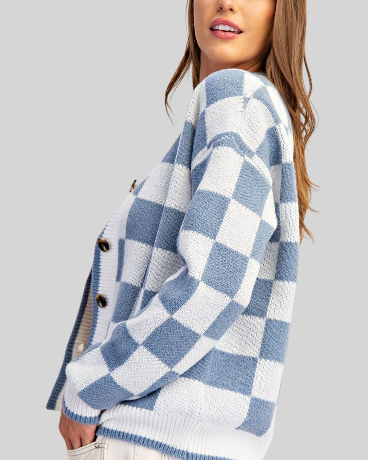 Side view of a blue and white checkerboard cardigan sweater.