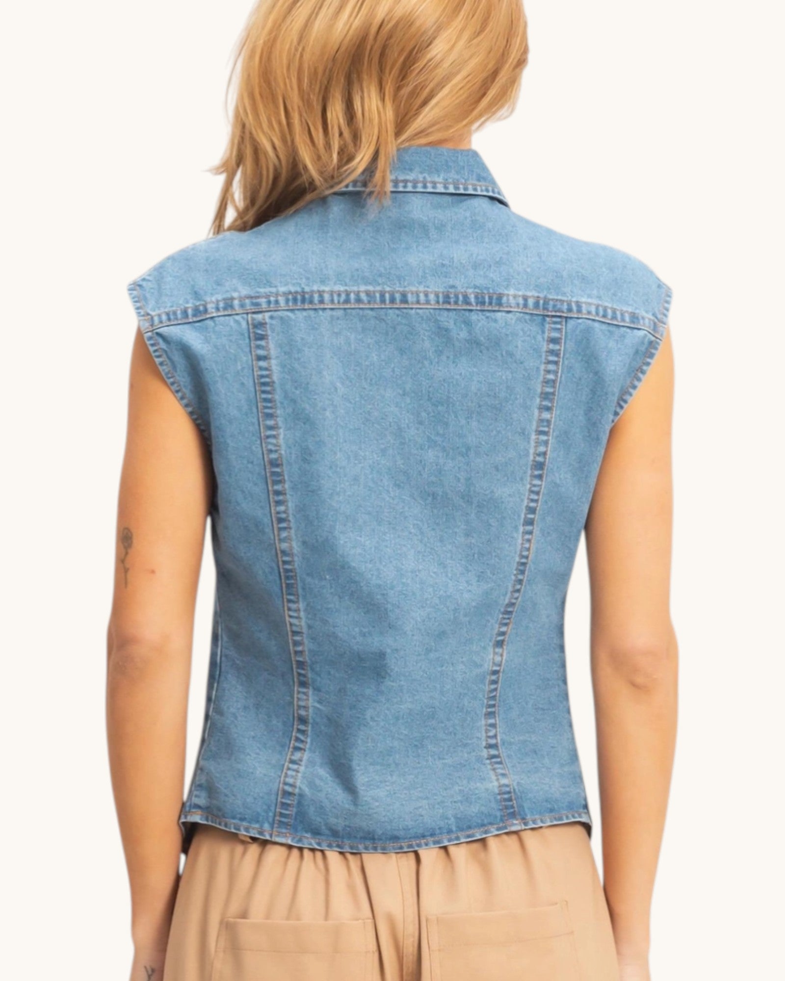 Denim vest worn by a person on a white background