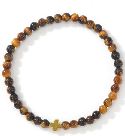 Beaded bracelet with a gold cross charm on a white background.
