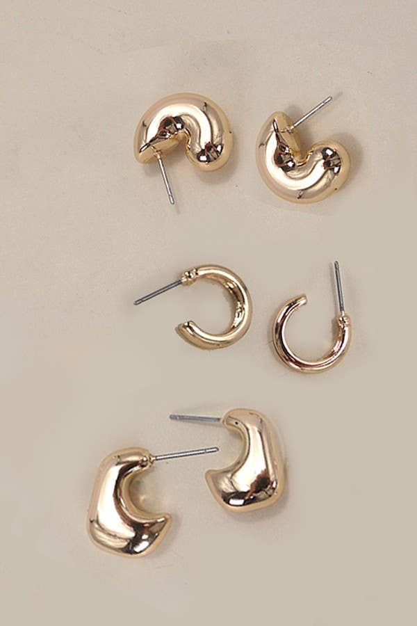 Set of three gold hoop bubble earrings on a beige background