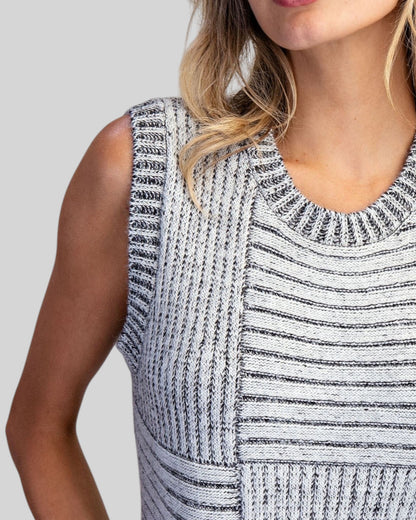 Close up of a charcoal and ivory mixed knit sleeveless sweater vest with crew neckline.