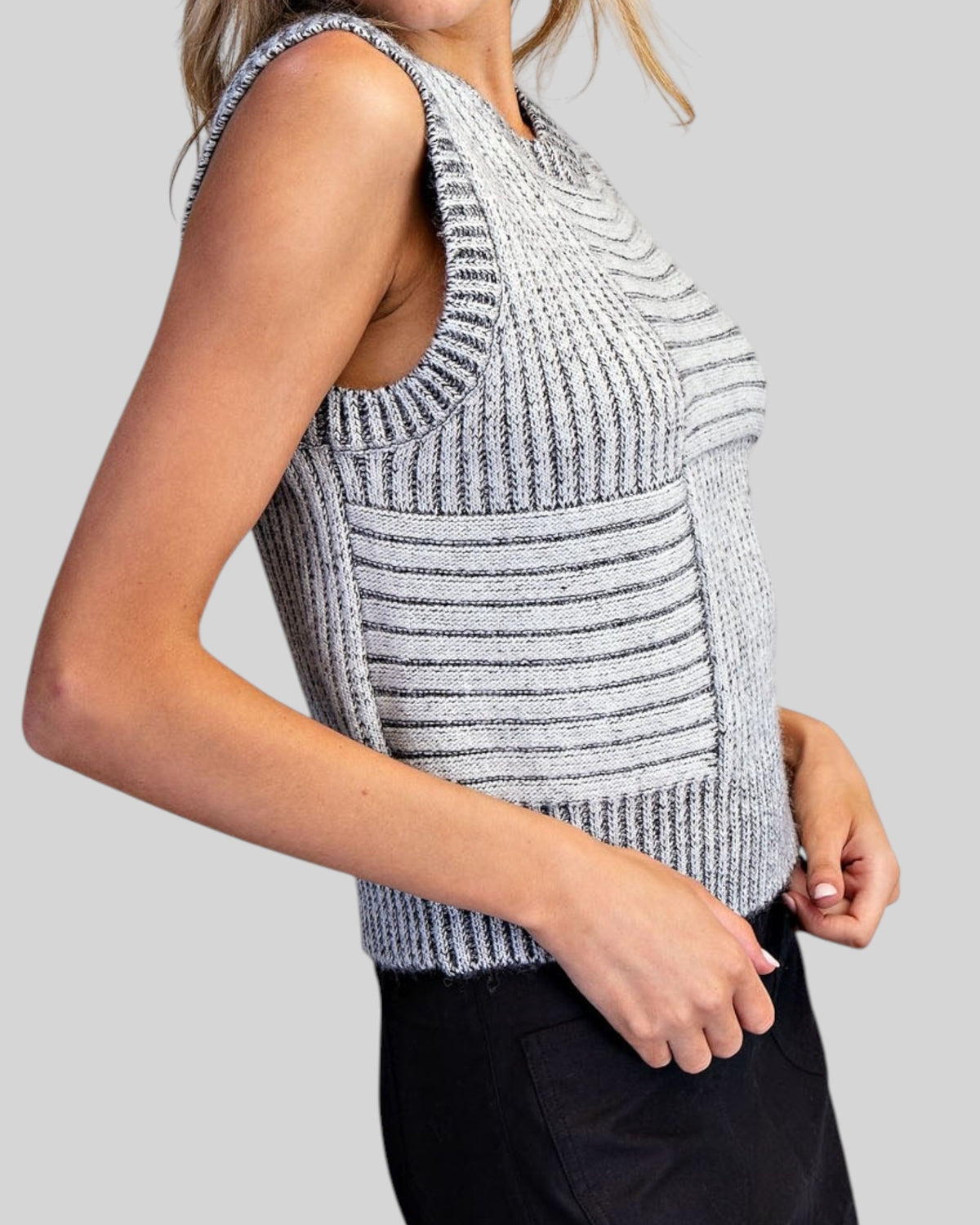 Side view of a charcoal and ivory mixed knit sleeveless sweater vest with crew neckline and cropped length.