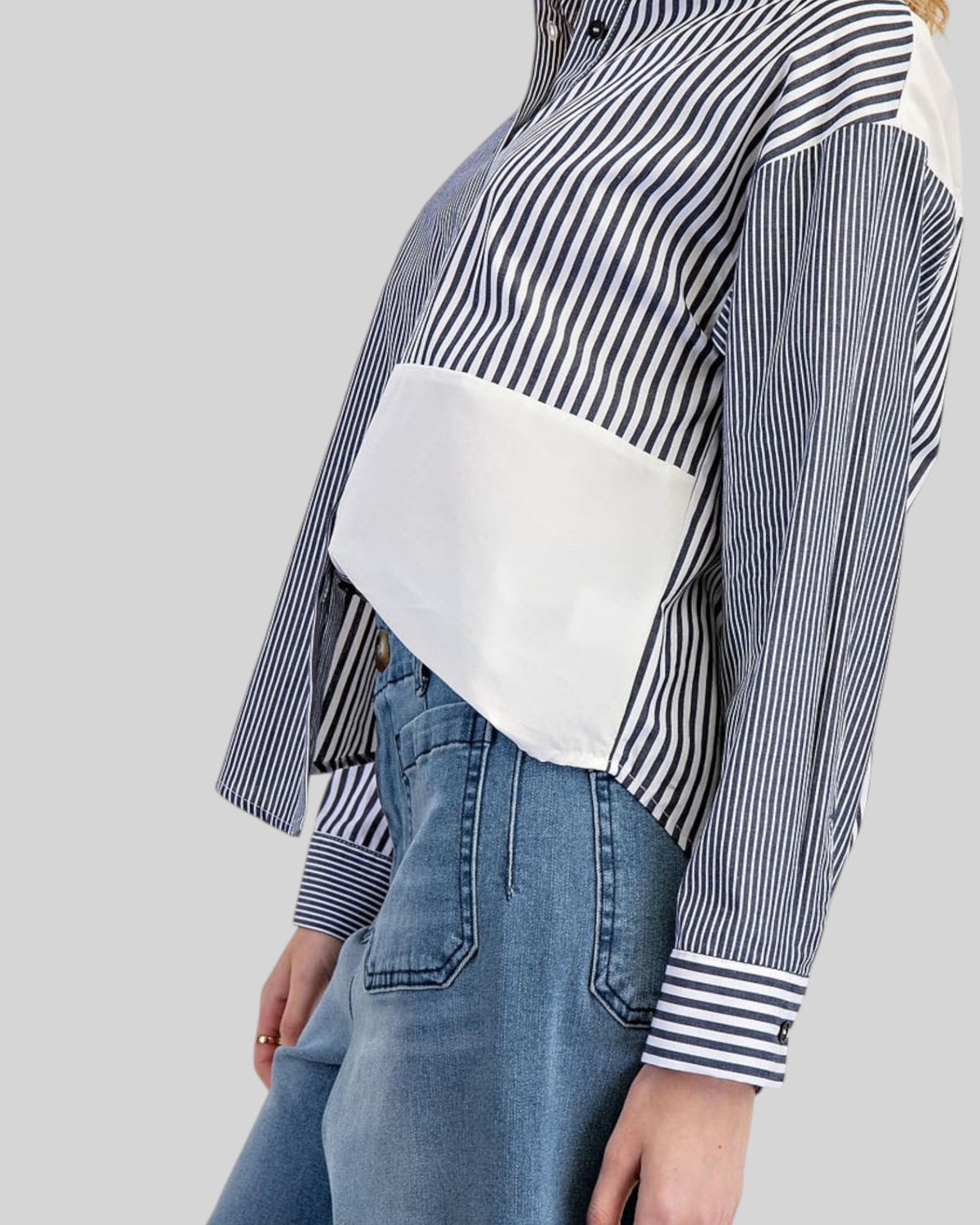 Side view of a mixed stripe charcoal and white button down shirt.