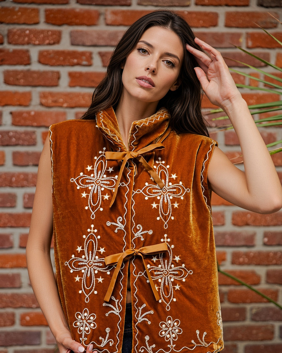 Woman wearing a vintage inspired Copper velour vest with ivory floral embroidery, oversized collar, tie-front closures, and scalloped trim.