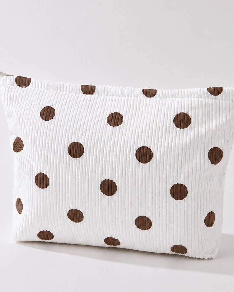 Ivory corduroy make-up bag with brown polka dots against a light background. 