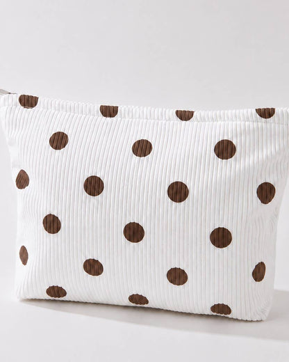 Ivory corduroy make-up bag with brown polka dots against a light background. 