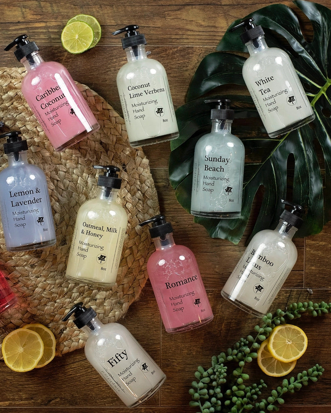 Assorted bottles of hand soaps on a wooden surface with decorative elements.