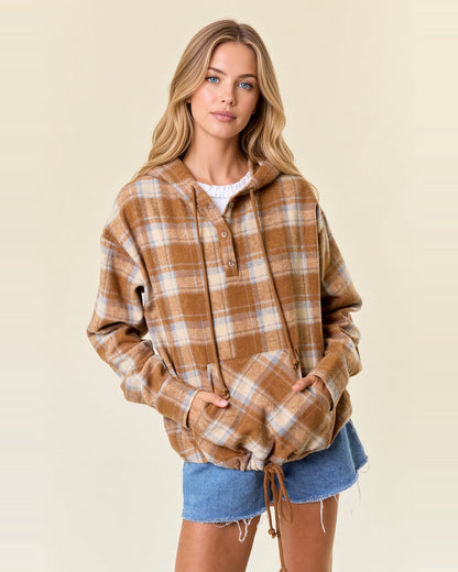 Front view of acorn brown plaid flannel hoodie with a partial button placket and hands in the kangaroo pocket.