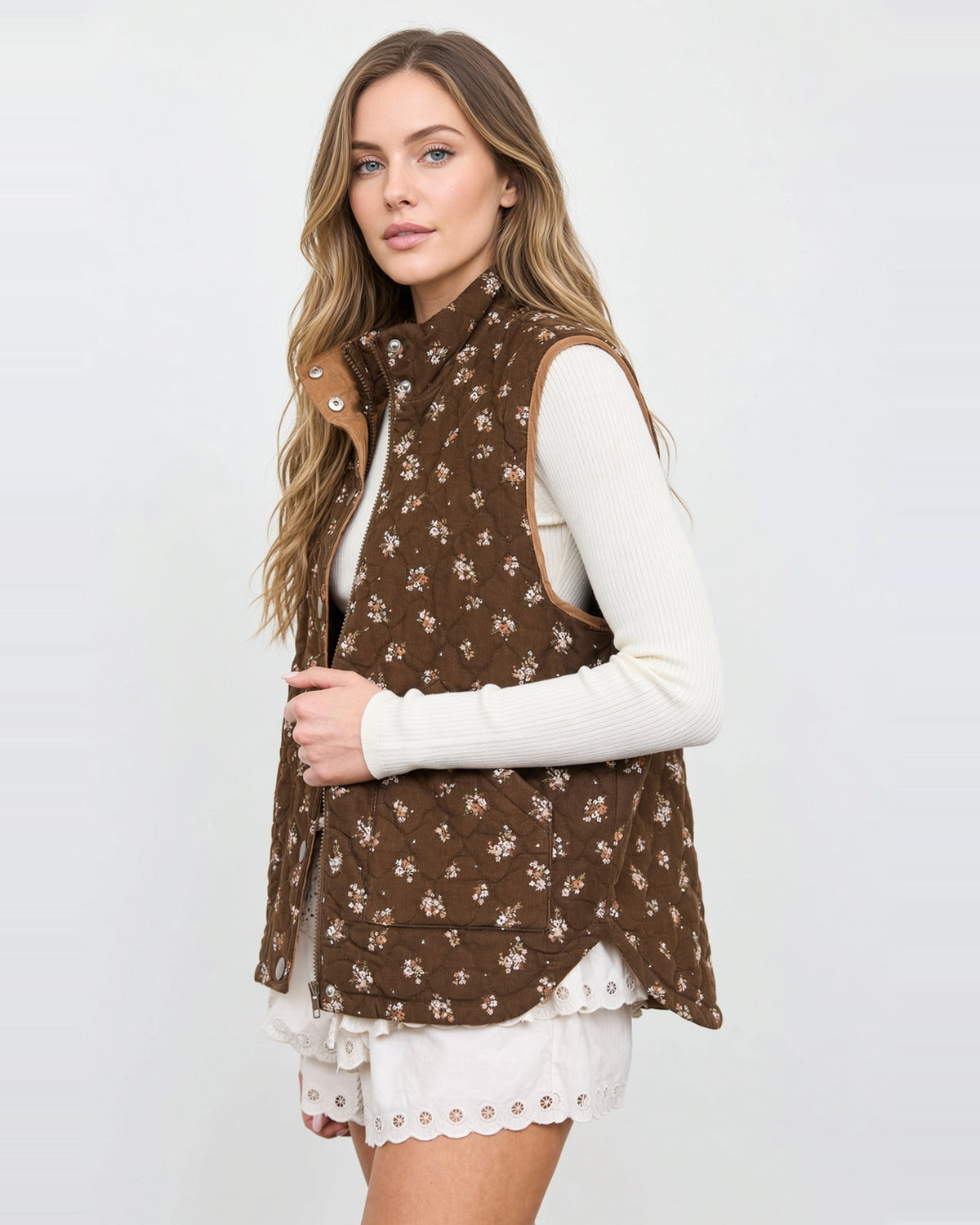 Side view of the Hazel Bloom brown floral quilted vest, showing its roomy armhole and side pocket.