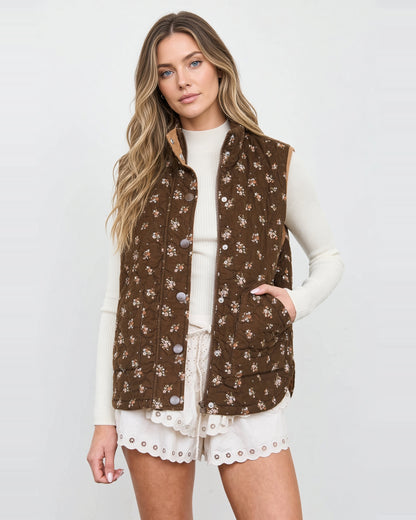 Model wearing a brown floral quilted vest with a stand collar, snap-front placket, and angled pockets.