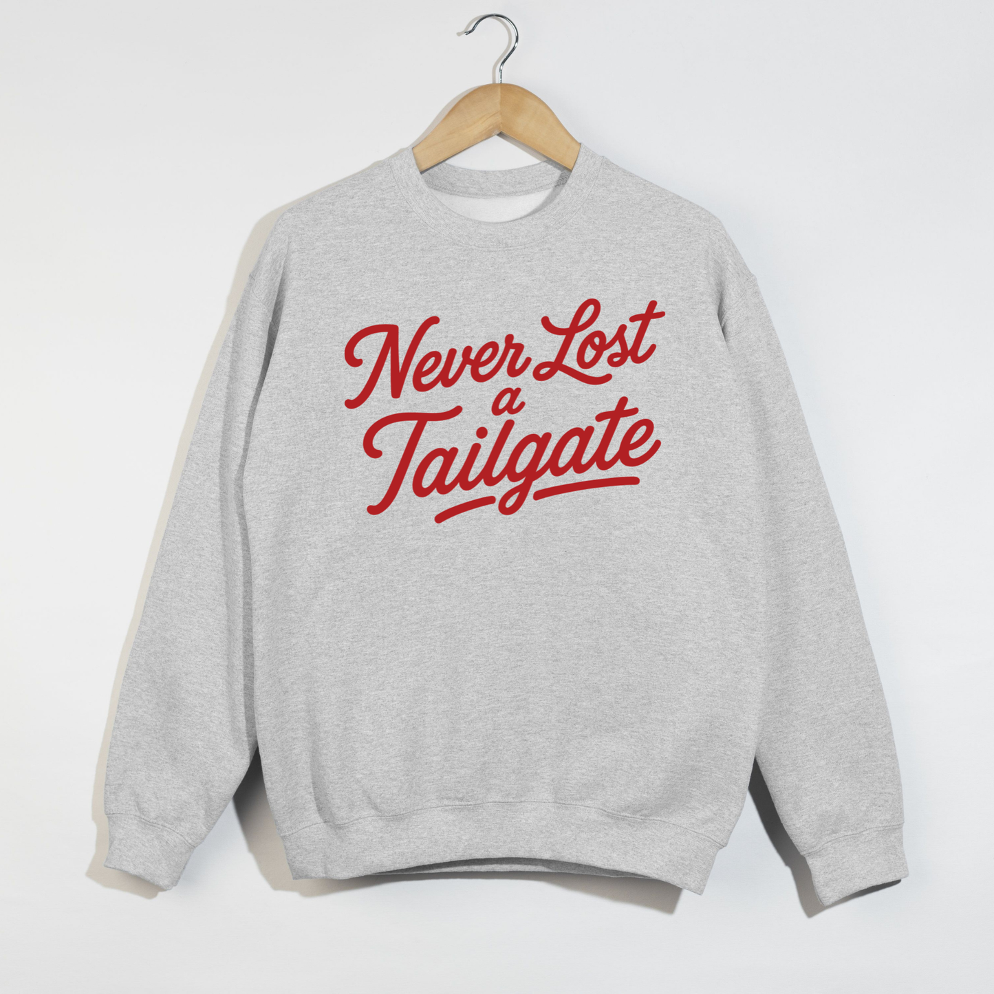 Gray sweatshirt with 'Never Lost a Tailgate' text in red on a white background.