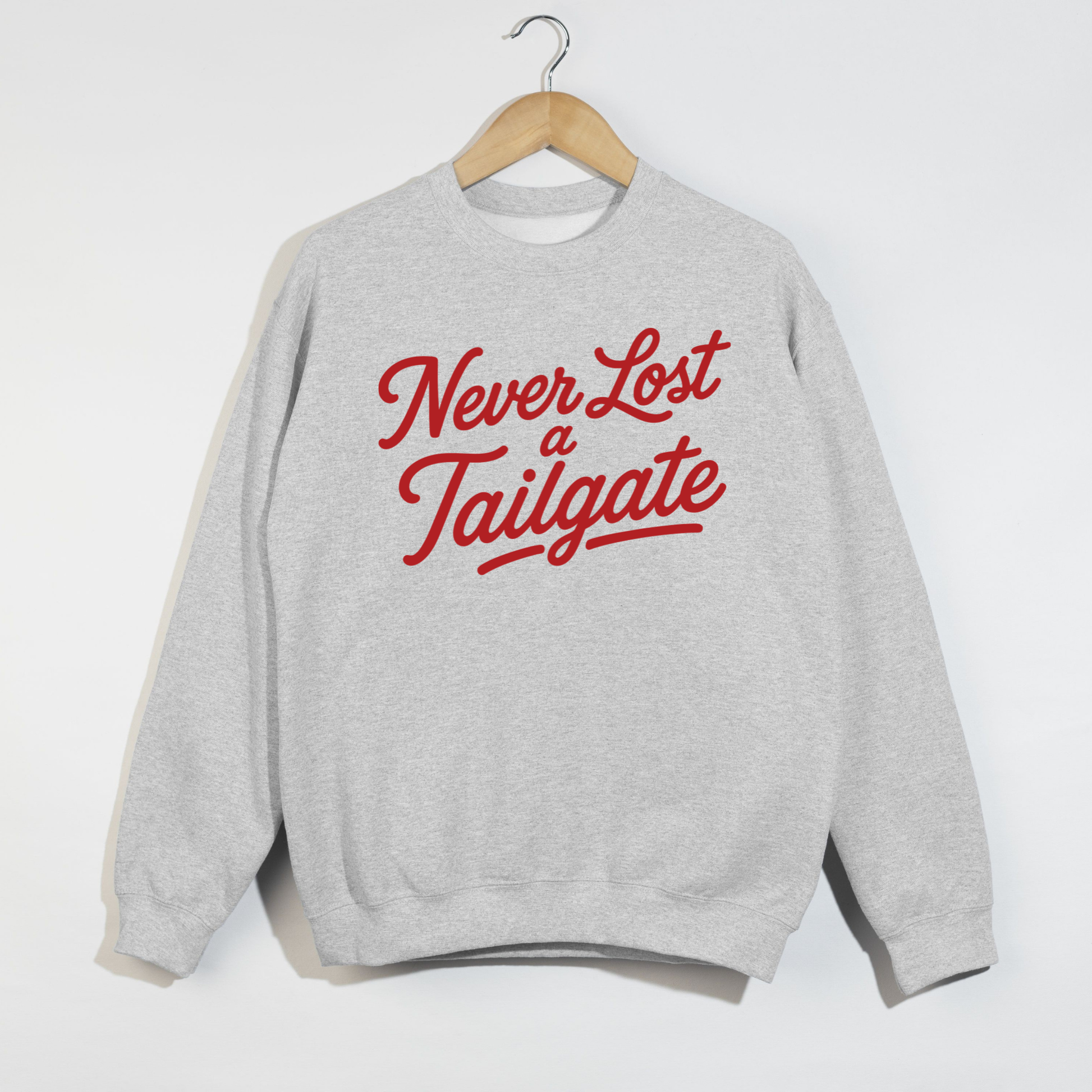 Gray sweatshirt with 'Never Lost a Tailgate' text in red on a white background.