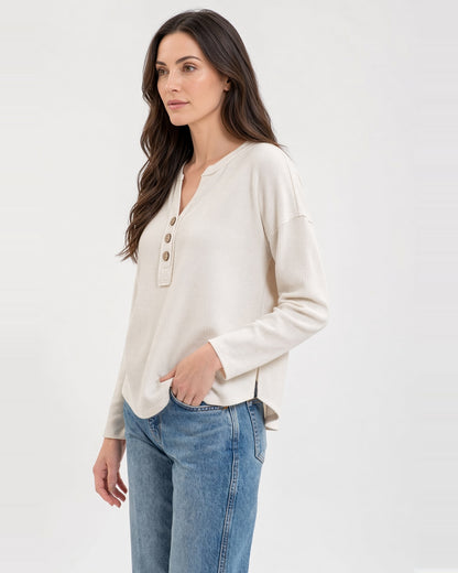 Side view of the Soft Ivory half-button top, showing dropped shoulders and a split hem with a longer back.
