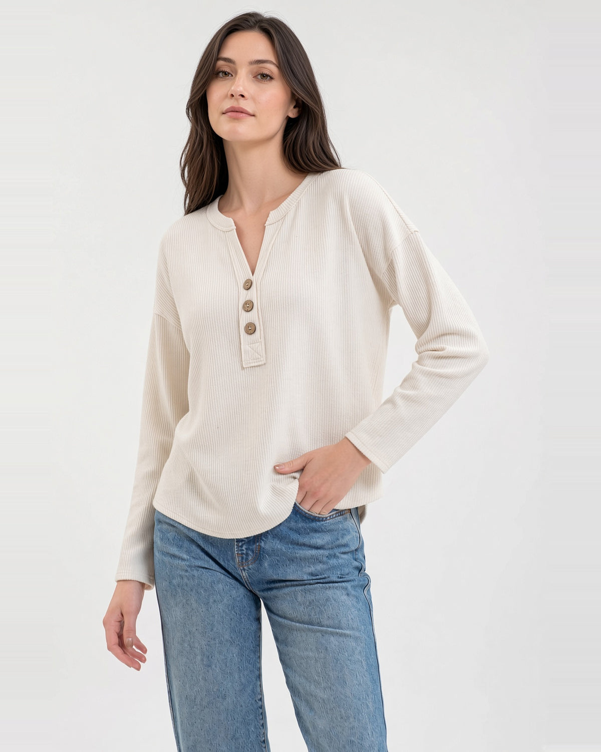 Model wearing an ivory textured knit top with a three-button neckline, long sleeves, and relaxed fit.