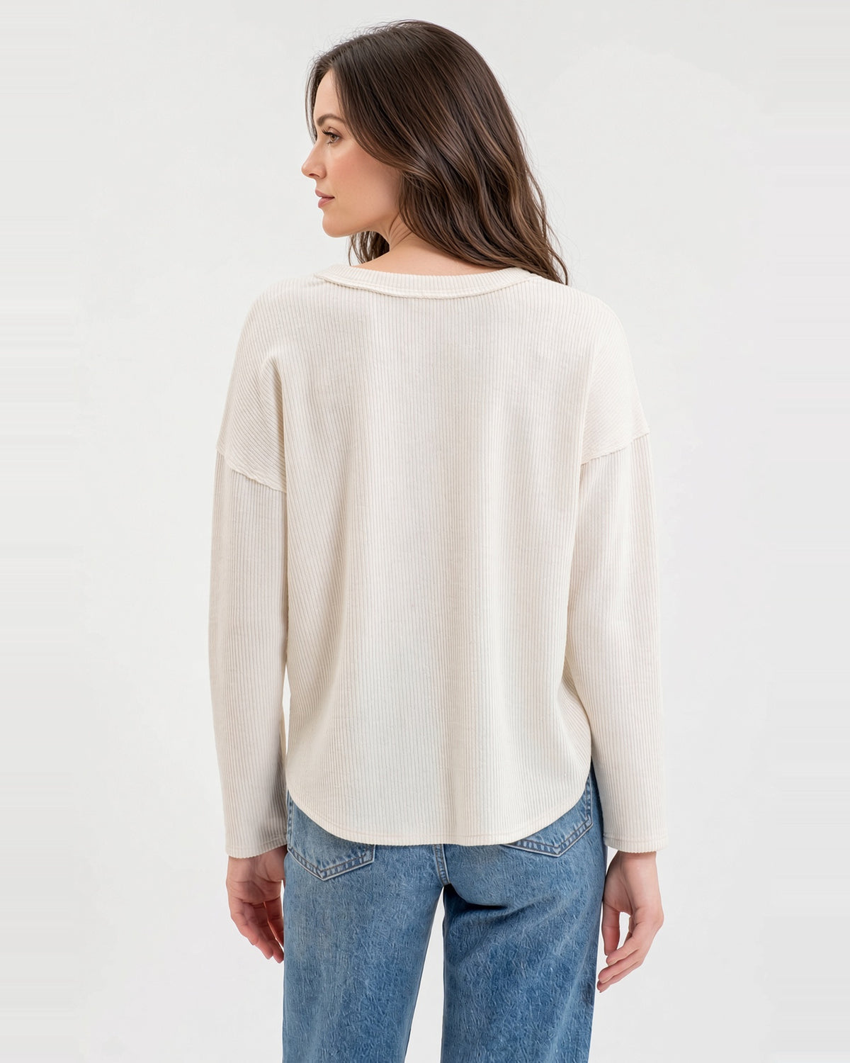 Back view of the Soft Ivory long sleeve top, showing textured knit, exposed shoulder seams, and a curved hem.