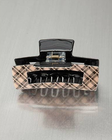 A brown plaid hair claw clip on a silver metallic background. 