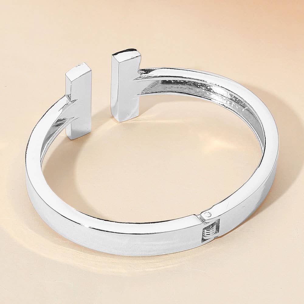 Silver cuff hinge bracelet on a beige background.