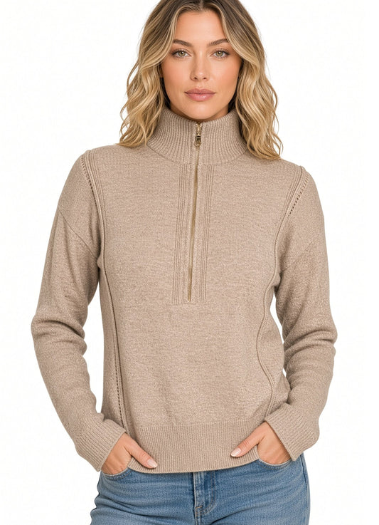 A woman modeling a heather beige/mocha ribbed knit mock neck quarter zip sweater with side pockets, paired with blue jeans against a plain white background.