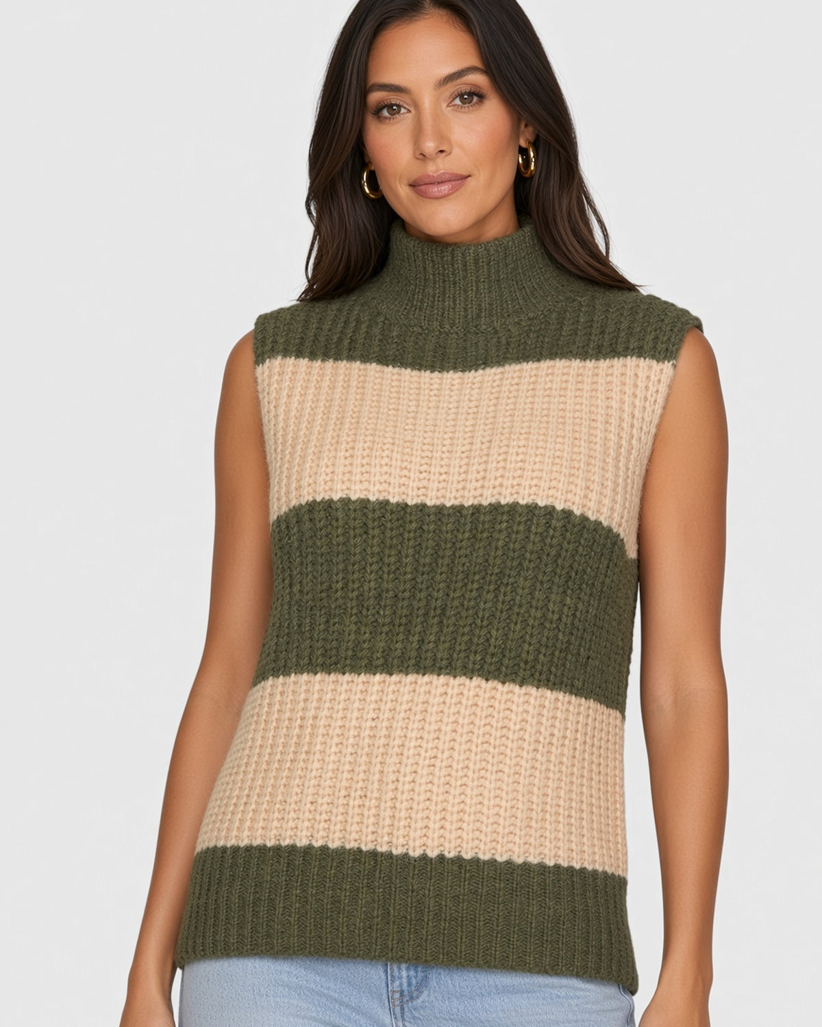Woman wearing chunky knit mock neck sleeveless sweater in olive and beige horizontal stripes. 