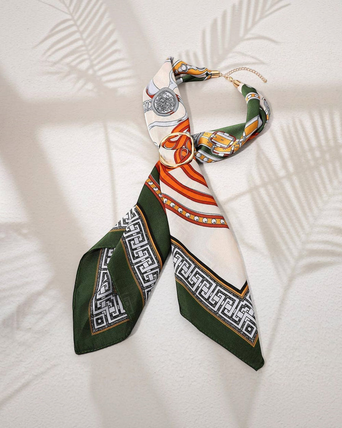 Adjustable scarf necklace with gold hardware and an abstract print in olive, red, orange, yellow and ivory.