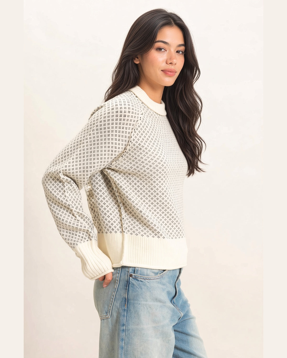 Side view of cream and charcoal birdseye knit sweater showing relaxed fit and ribbed hem.
