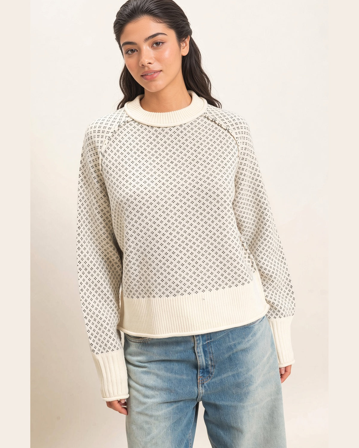 Front view of cream knit sweater with charcoal birdseye pattern, raglan sleeves, and wide ribbed cuffs and hem.
