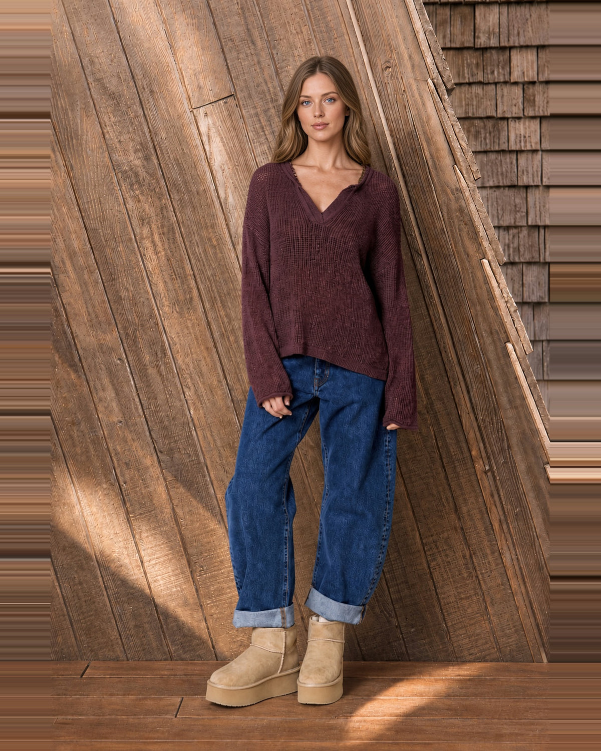 Model wearing Mulled Wine split-neck knit sweater with jeans and tan boots.