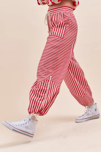 Red and white striped harem style parachute pants worn with white sneakers