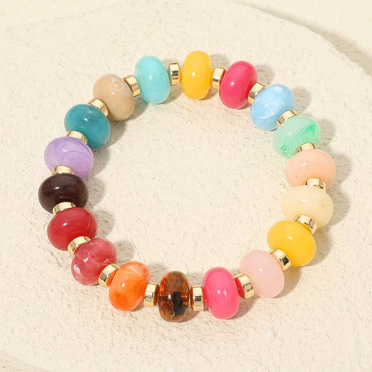 Multicolored beaded bracelet on a beige background.