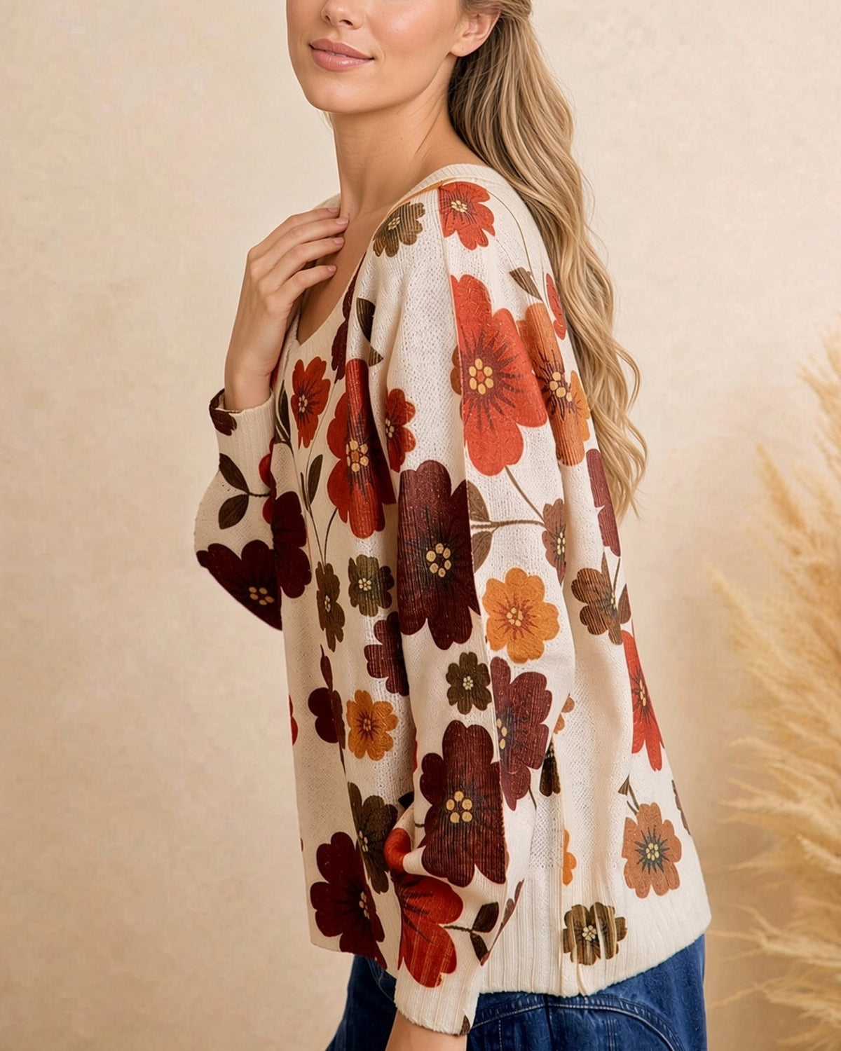 Side view of cream retro floral sweater showing loose fit, dropped shoulders, and long sleeves.