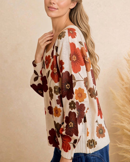 Side view of cream retro floral sweater showing loose fit, dropped shoulders, and long sleeves.