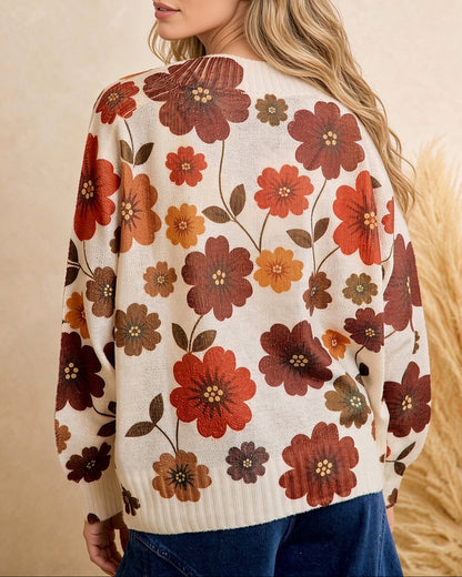 Back view of cream knit sweater with allover rust, burgundy, mustard, and olive floral print and ribbed hem.