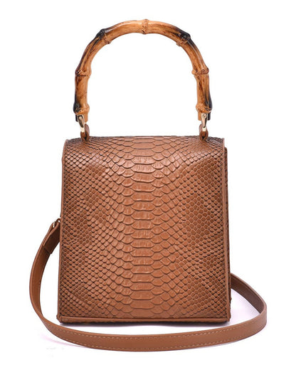Back view of a brown structured snakeskin handbag with bamboo handle and shoulder strap.