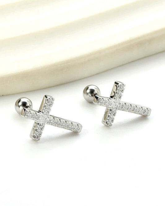 Silver cross shaped rhinestone earrings on a white background.