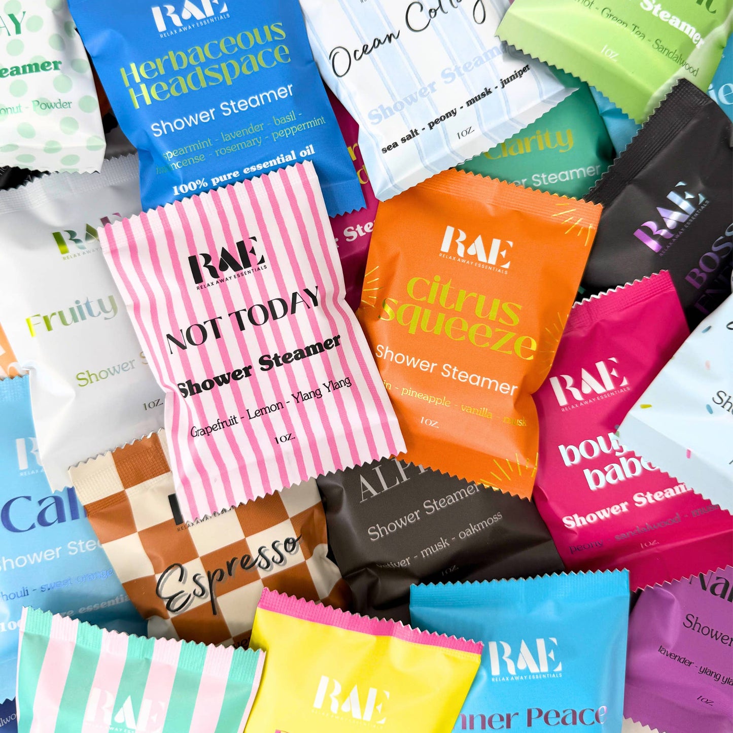 Assorted RAE Shower Steamer packets in various colors and scents.
