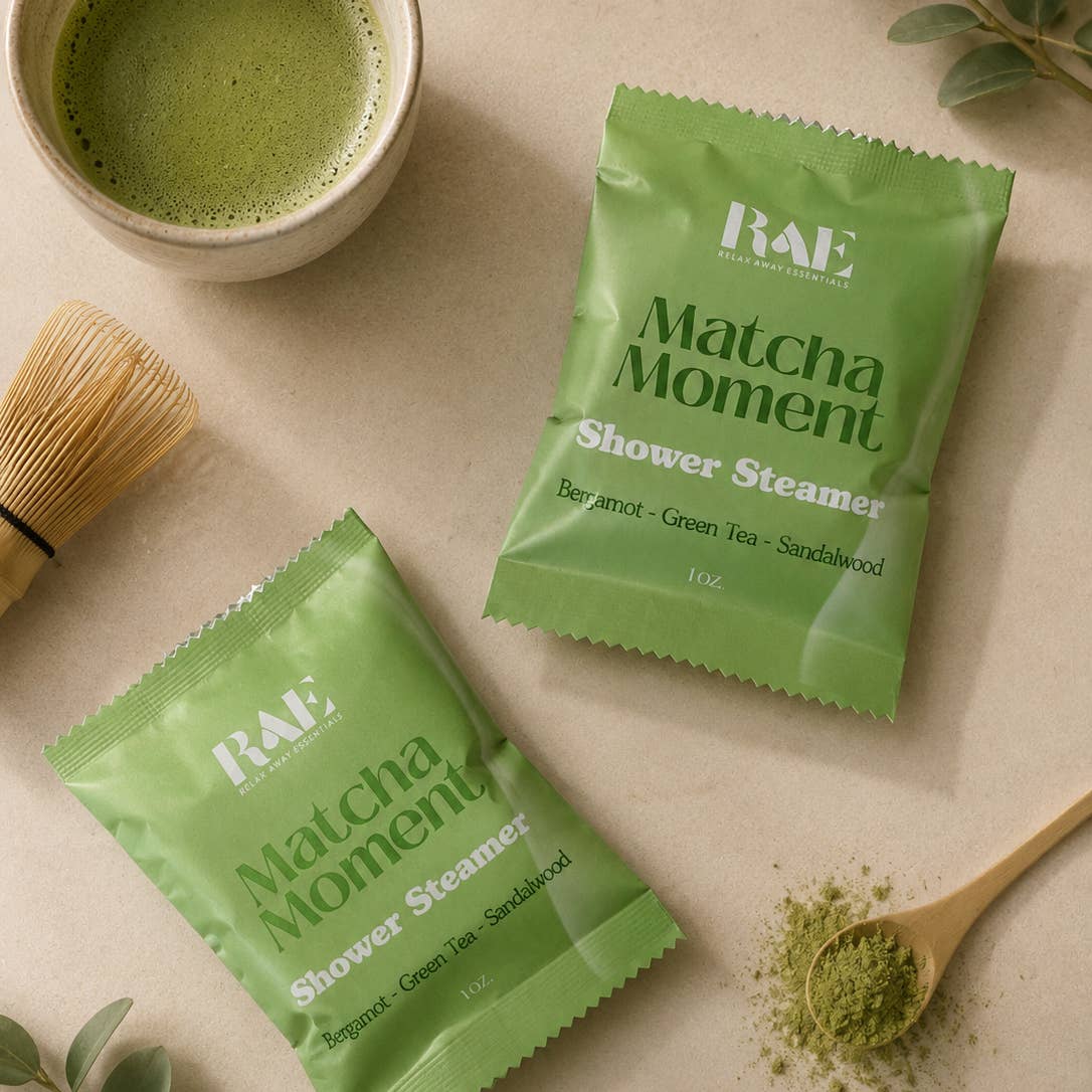 RAE Matcha Moment shower steamers with a cup of matcha and wooden spoon on a beige background.