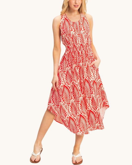 A woman modeling a sleeveless midi dress with a red and white palm leaf pattern, set against a plain off-white background.