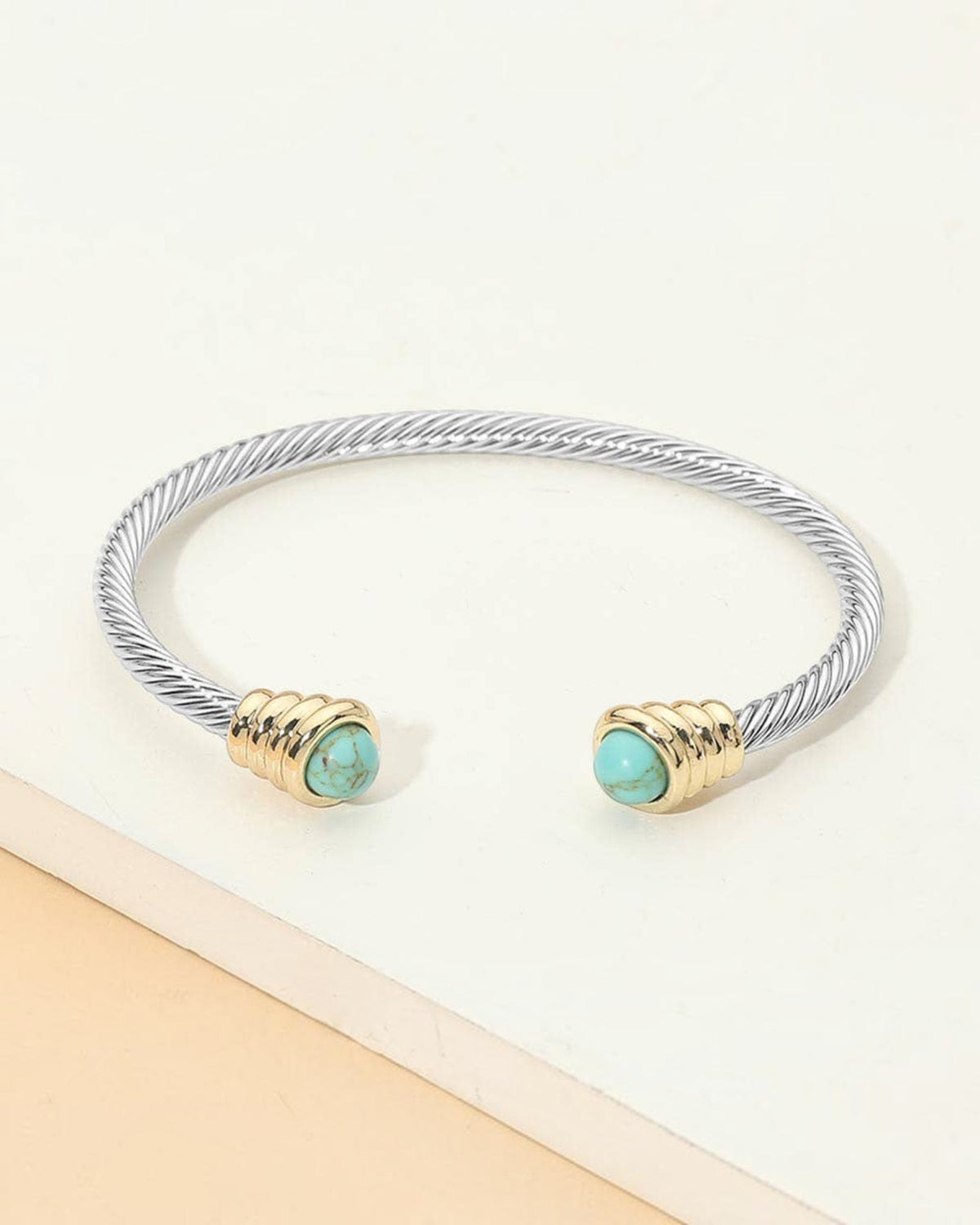 Turquoise tip silver open cuff cable bracelet with gold accents.