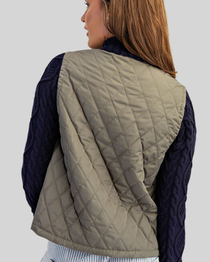 Back view of a Navy and olive mixed-media jacket with quilted body, navy cable knit sleeves.