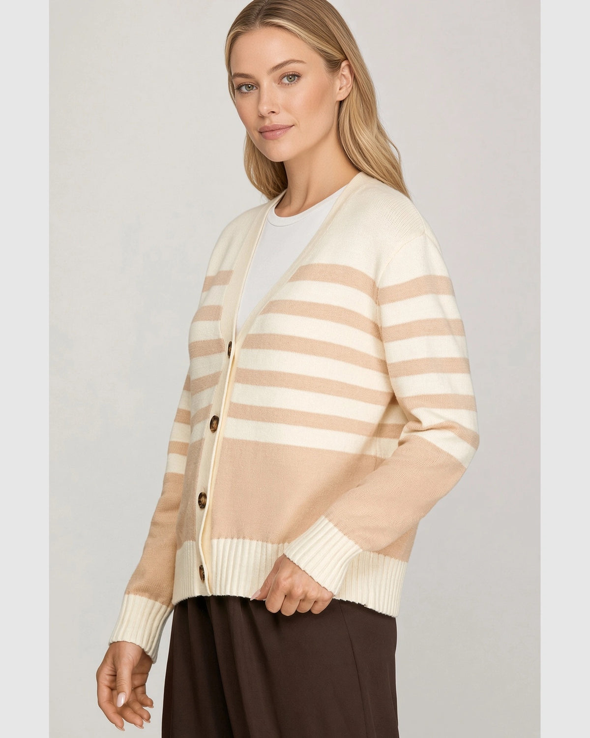 Full-length view of model wearing taupe and cream striped button-front cardigan with brown pants.