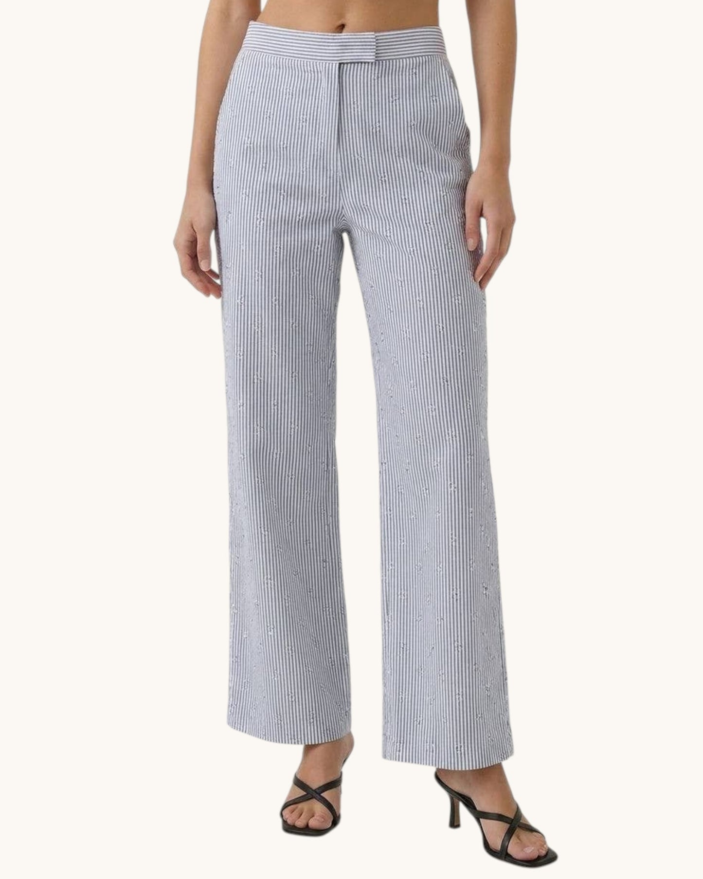 Woman wearing black and white striped pants on a white background.