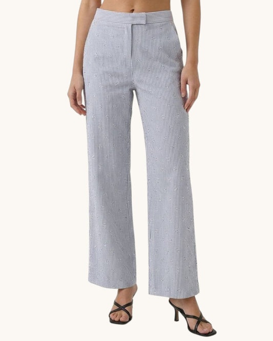 Woman wearing black and white striped pants on a white background.