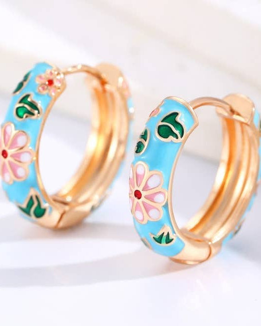 Blue enamel vintage inspired hoop huggies with floral and gold accents. 