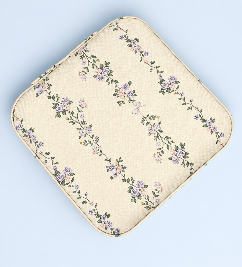 An off-white floral pouch with a repeating pattern of purple and pink flowers and green leaves, shown on a light blue background.