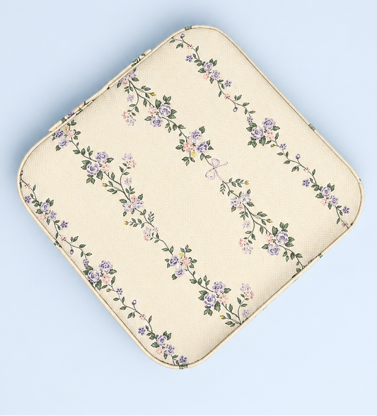 An off-white floral pouch with a repeating pattern of purple and pink flowers and green leaves, shown on a light blue background.