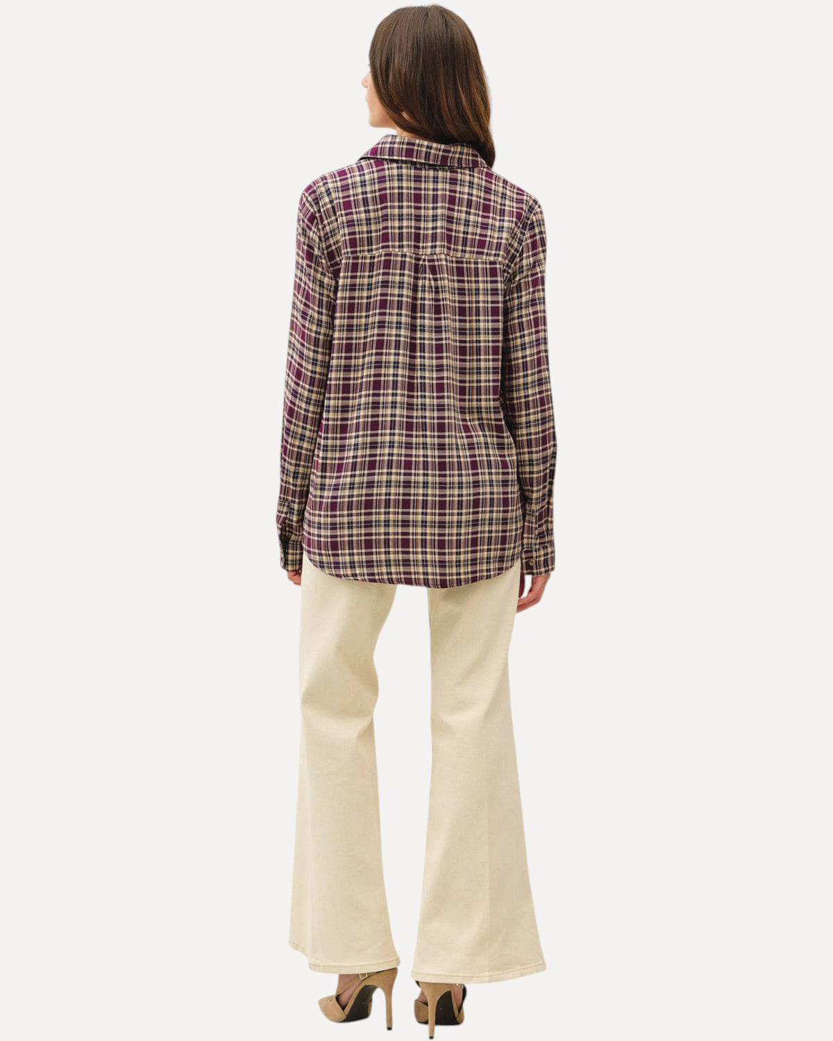 Back view of a model wearing a mixed plum plaid button down long sleeve top and khaki pants and nude heels.