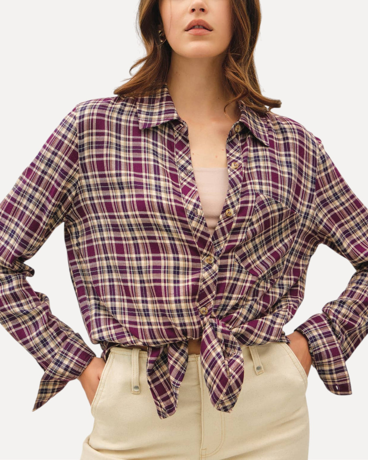 Model wearing a mixed plum plaid button down long sleeve top tied at the waist with a relaxed fit, cuffs and classic collar. 
